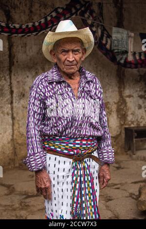Der 90-jährige Maya-Mann in traditioneller Kleidung steht vor seinem Haus in San Pedro la Laguna, Guatemala. Stockfoto