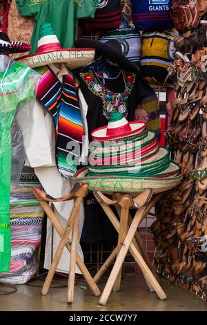 Touristische Souvenirs, darunter ein Stapel mexikanischer Sombreros zum Verkauf in einem Touristengeschäft in Tijuana, Mexiko. Stockfoto