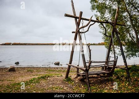 Hölzerne Schaukel auf dem See durch Herbstwolke Tag Stockfoto