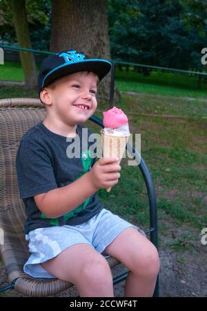 Polnische Kleinkind gründlich genießen seine Eis (lody) Kegel. Rzeczyca Mittelpolen Europa Stockfoto