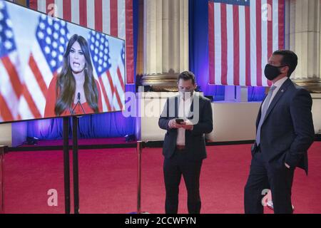 Washington, Usa. August 2020. Donald Trump Jr. (R) trägt eine Gesichtsmaske, um das Risiko der Übertragung des neuartigen Coronavirus zu reduzieren, und beobachtet seine Freundin Kimberly Guilfoyle, während sie ihre Rede vor der Republikanischen Nationalversammlung im Mellon Auditorium am 24. August 2020 in Washington, DC, aufzeichnet. Die neue Coronavirus-Pandemie hat die Republikanische Partei gezwungen, sich von einer persönlichen Konvention zu einem Fernsehformat zu bewegen, ähnlich wie die Versammlung der Demokratischen Partei eine Woche zuvor. Pool Foto von Chip Somodevilla/UPI Kredit: UPI/Alamy Live Nachrichten Stockfoto