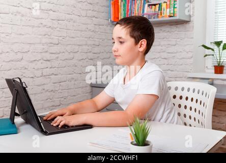 Kind, das zu Hause studiert und während der Quarantäne auf den Laptop-Bildschirm schaut Stockfoto
