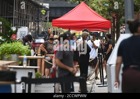 New York City, USA. August 2020. Gäste, die auf Bestellung warten und auf ihre Bestellungen warten, sahen sich im Chelsea Market Outdoor Dining Bereich an der 15th Street, New York, NY, 24. August 2020 an. Das Kollektiv, aus dem der Chelsea Market, sowohl Lebensmittelhändler als auch Einzelhändler, besteht, hat am 17. August als Reaktion auf die Beschränkungen des Innenrestaurants der Stadt aufgrund der COVID1-9-Pandemie einen fast blocklangen Essbereich für Einkäufer an der 15th und 16th Street zwischen 9th und 10th Avenue eingerichtet. (Anthony Behar/Sipa USA) Quelle: SIPA USA/Alamy Live News Stockfoto