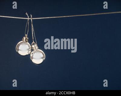 Weihnachtstisch mit silbernen Hängekugeln. Weihnachtskomposition, Weihnachtskugeln auf blauem Hintergrund hängend, Platz für Text Stockfoto