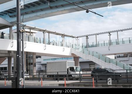 Verkehr von Menschen auf Fußgängerbrücke und Autos fahren auf der Straße. Stadtleben in Tokio, Japan Stockfoto