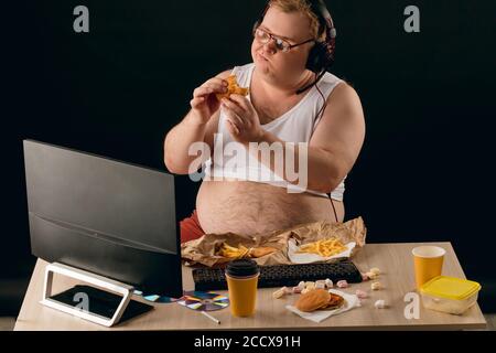 Fettleibiger Kerl hat die Ernährung mit leckeren Hamburger ruiniert. Völlerei Konzept. Mann kann seinen Appetit nicht kontrollieren. Genußment.man bekommt Vergnügen vom Essen favori Stockfoto