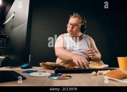 Mann mit dicken Wangen essen Frühstück mit Völlerei. Nahaufnahme Seitenansicht Foto. Isolierte schwarze background.Fat Mann mit dem Mund voll von Lebensmitteln Browsing die Stockfoto