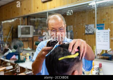 Barber bei der Arbeit in Thon Buri Nachbarschaft von Bangkok Stockfoto