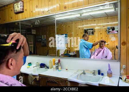 Barber bei der Arbeit in Thon Buri Nachbarschaft von Bangkok Stockfoto