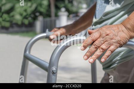 Ältere Frau, die eine Gehstraße überquert Stockfoto
