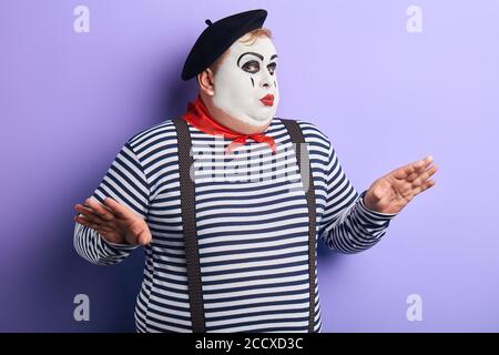 Talentierter Schauspieler mit erhobenen Armen zeigt Pantomime. Nahaufnahme Porträt, isoliert blauen Hintergrund, Studio erschossen. Stockfoto