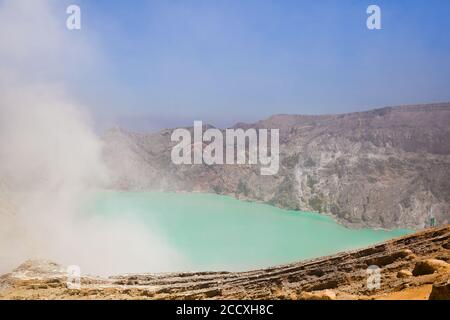 Vulkan Ijen. Krater eines Vulkans mit einem grünen Schwefelsee und vulkanischem Rauch. Blick auf den rauchenden Vulkan Kawah Ijen in Indonesien. Mountai Stockfoto