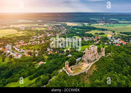 Csesznek, Ungarn - Luftpanorama auf dem Hügel Schloss von Csesznek und Csesznek Stadt bei Sonnenuntergang an einem sonnigen Sommernachmittag Stockfoto