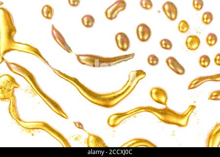 Goldene Tinte Tropfen auf weißem Papier Hintergrund. Stockfoto