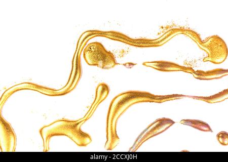 Goldene Tinte Tropfen auf weißem Papier Hintergrund. Stockfoto