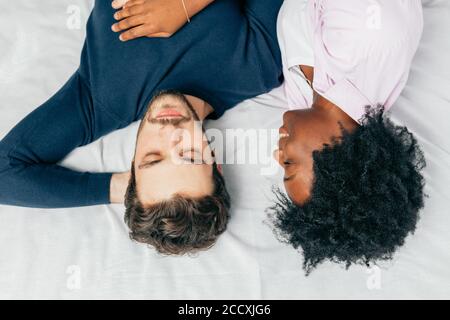 Close-up Happy interracial Paare schlafen im Bett zusammen, genießen die Gesellschaft des jeweils anderen. Komfort und Entspannung. Stockfoto