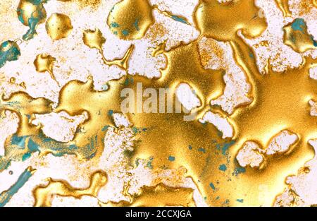 Goldene Tinte Tropfen auf weißem Papier Hintergrund. Stockfoto