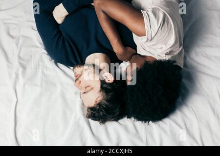 Close-up Happy interracial Paare schlafen im Bett zusammen, genießen die Gesellschaft des jeweils anderen. Komfort und Entspannung. Stockfoto