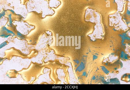 Goldene Tinte Tropfen auf weißem Papier Hintergrund. Stockfoto