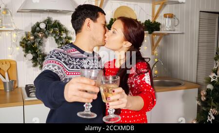 Brunette Frau und Mann jubelt mit Gläsern Champagner gratuliert Und küssen sich gegenseitig aus der Nähe Stockfoto