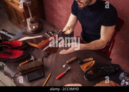 Schuster setzen auf Schuh in das Leder. Nahaufnahme 7/8 Foto. Messung Konzept Stockfoto