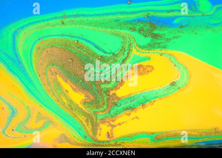 Grüne und gelbe Wellenstruktur mit goldener Pulverstreuung. Stockfoto
