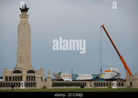 Portsmouth, Hampshire, Großbritannien. August 2020. Ein Kran, neben dem Portsmouth Naval Memorial war Memorial, wird verwendet, um den LCT 7074, den letzten überlebenden amphibischen Landungsschiff-Panzer, vorzubereiten, der am Montag, dem 24. August 2020, in das D-Day Museum in Portsmouth verlegt werden soll. Das Schiff, das ursprünglich Panzer und Soldaten in die Normandie transportierte, wurde von einem Lastkahn aus dem Nationalmuseum der Royal Navy, wo es restauriert wurde, zur Promenade in Southsea gebracht, wo ein Kran eine Brücke zum Lastkahn baute, So konnte es in sein neues Zuhause im D-Day Museum gebracht werden. Kredit: Luke MacGregor/Alamy Live Nachrichten Stockfoto