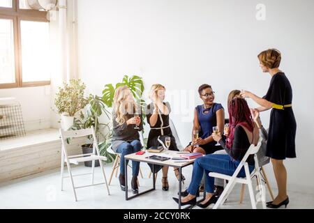 Positive, Elegant, attraktiv, fröhlich, Business Damen in casual Outfits feiern Veranstaltung klirren Gläser mit Champagner bei Geburtstag Mädchen suchen, Stockfoto