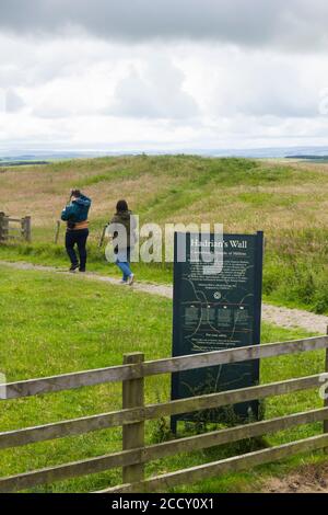 Zwei Menschen zu Fuß entlang des Fußweges bei Brocolitia Tempel von Mithras, ein Mithraeum, in der Nähe der Stelle der römischen Festung von Carrawburgh, Northumberland. Stockfoto