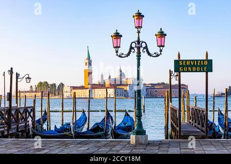 Laterne und geparkte Gondeln am Ende des Markusplatzes mit Blick auf die Basilika San Giorgio Maggiore, Venedig, Venetien, Italien Stockfoto