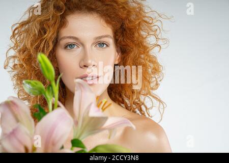 Schöne rothaarige Dame posiert auf dem grauen Hintergrund Stockfoto