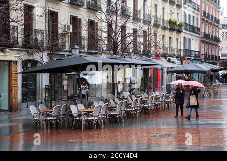 Empy Sitze in Terrassen des chueca-Platz im Homosexuell-Viertel, wie die Menschen an einem regnerischen Tag, Madrid Stockfoto