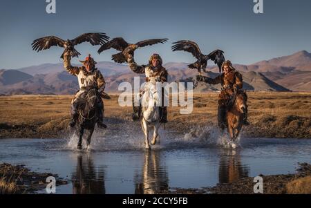 Mongolischer Adlerjäger, drei Kasachen zu Pferd mit ausgebildeten Adlern, Bajan-Oelgii Provinz, Mongolei Stockfoto