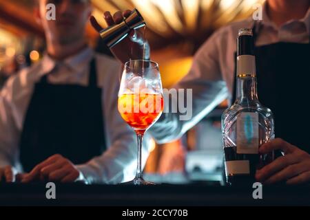 Barkeeper Hand Rühren eines frischen und süßen orange Sommer Cocktail mit einem Löffel auf der Theke. Stockfoto