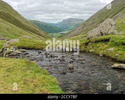 Blick nach Norden hinunter Kirkstone Pass, Cumbria in Richtung Brothers Water mit Platz fiel in der Ferne an einem trüben und windigen August Tag. Stockfoto