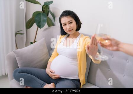 Kein Alkohol während der Schwangerschaft. Junge schwangere Frau weigert sich, Wein zu trinken, Stop-Geste zu Glas, freien Raum Stockfoto