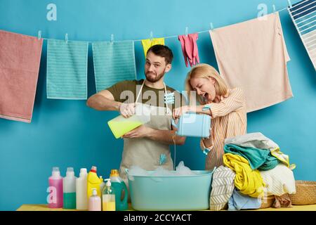 Aufgeregt emotionale blonde Frau und beraded Mann mit Waschmitteln in den Händen. Nahaufnahme Porträt. Isoliert blauen Hintergrund.Glück Konzept. Stockfoto