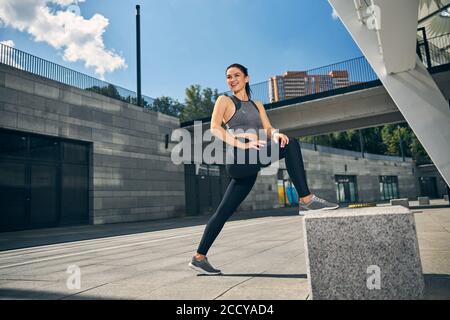 Positive begeistert junge Frau tun Stretching-Übung Stockfoto