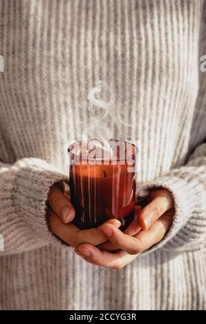 Frau in kuscheligen Pullover mit Kerze in Nahaufnahme Stockfoto