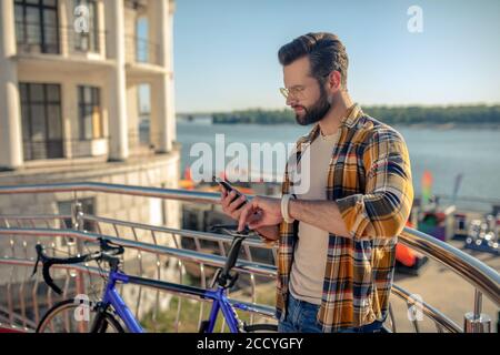 Aufmerksamer Mann mit Smartphone und Fitness-Armband Stockfoto