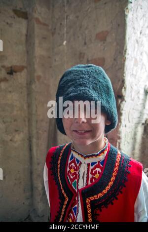 Ivanovo, Serbien, 09. April 2017. Ein Junge mit Sommersprossen im Gesicht in bulgarischer Nationaltracht und einem Hut, der für Fotografen posiert. Eine Erfassung des ph-werts