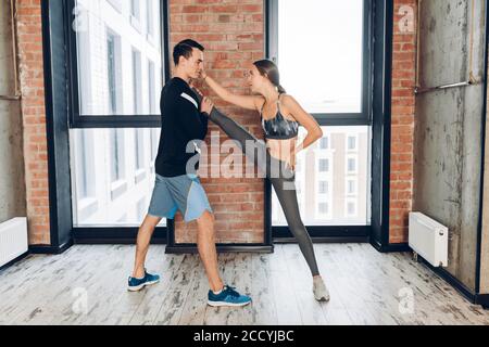 Junge Frau und Mann tut Karate in der Loft-Turnhalle. Nahaufnahme Foto. Kampfkunst. Kampf. Foto in voller Länge Stockfoto