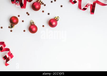 Weihnachtliche rote Farbkugeln, Kugeln und glitzernde Sterne Konfetti Dekoration Stockfoto