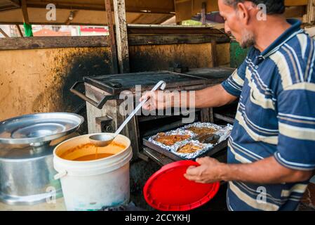 Ägypten, Hurghada lokaler Koch Mann Kochen Garnelen auf vintage Küche Einheit in der Nähe Fischmarkt Stockfoto