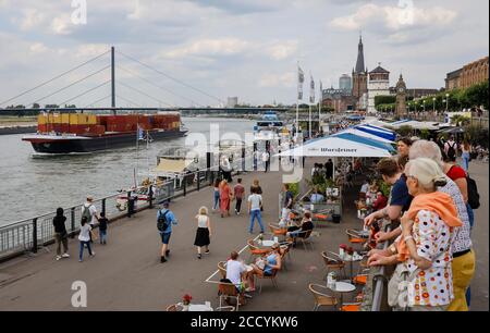 Düsseldorf, Nordrhein-Westfalen, Deutschland - Rheinuferpromenade in Zeiten der Corona-Pandemie laufen die Menschen am Rheinufer entlang und sitzen im c Stockfoto