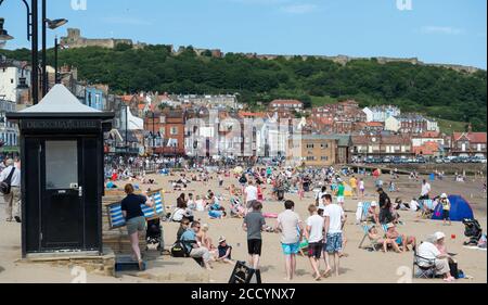 Sommeransicht der Besucher am überfüllten Strand von Scarborough In North Yorkshire Stockfoto