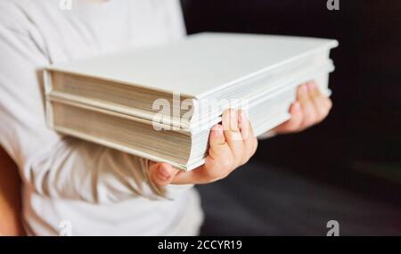 Frau trägt einen Stapel Bücher in einem ausleihen Bibliothek oder Bibliothek Stockfoto