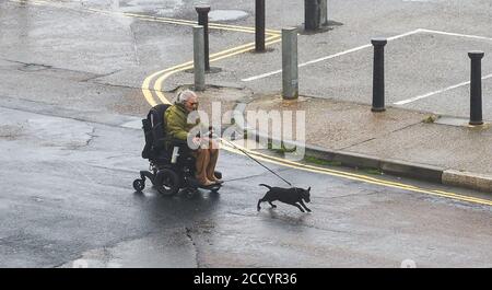 Brighton UK 25. August 2020 - Dieses Paar kämpft gegen die starken Winde und den Regen entlang der Küste von Brighton, während Sturm Francis heute durch Großbritannien fegt : Credit Simon Dack / Alamy Live News Stockfoto