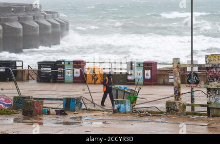 Brighton UK 25. August 2020 - EIN ratsarbeiter kämpft bei nassem und windigem Wetter am Black Rock in Brighton gegen die Elemente, während Sturm Francis heute durch Großbritannien fegt : Credit Simon Dack / Alamy Live News Stockfoto
