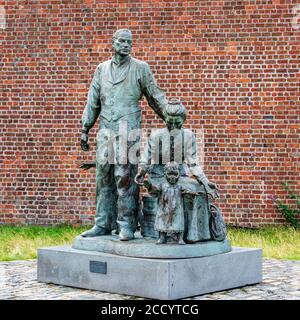 The Crossing von Mark DeGraffenried als Vertreter einer jungen Familie, die von Liverpool in die Neue Welt wandert - Albert Dock, Liverpool, England, Großbritannien Stockfoto